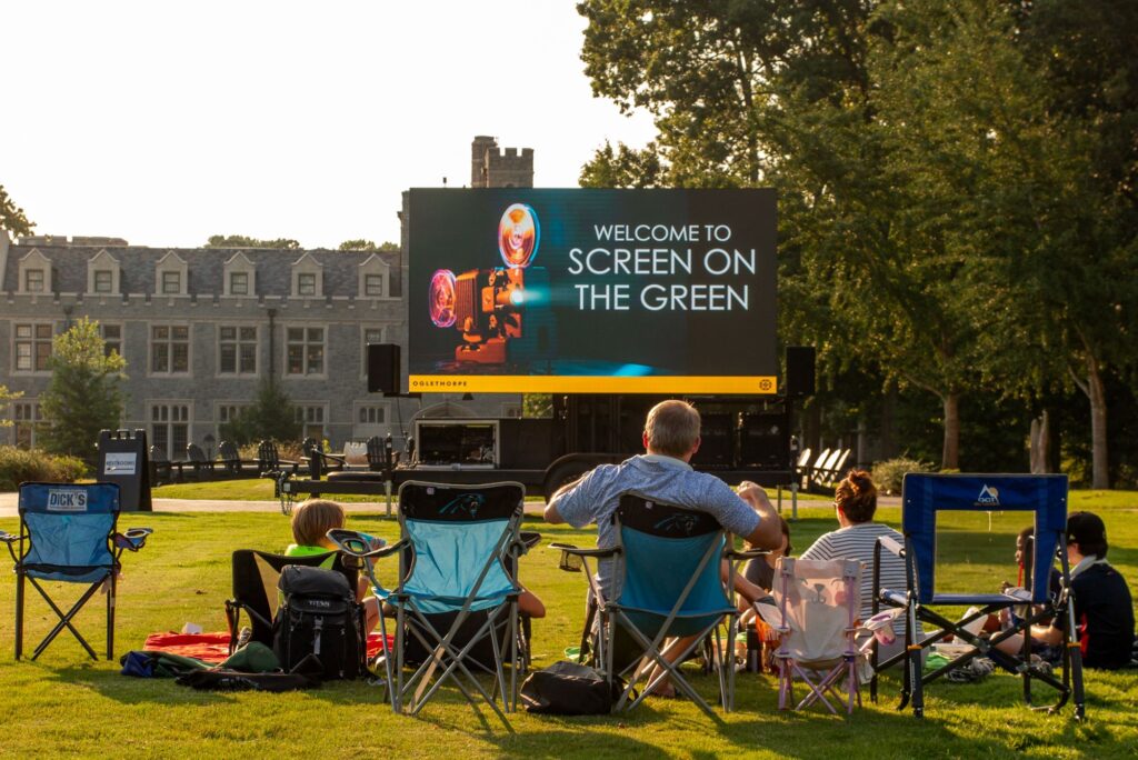 Alumni and families watching a movie on the Academic Quad