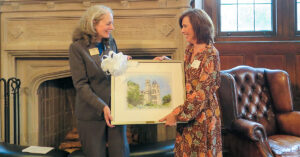 OU President Kathryn McClymond with alumna Donna Rasile '82 in Hearst Hall with a watercolor of Lupton Hall -- a parting gift for Rasile as she concluded her service to the President's Advisory Council.