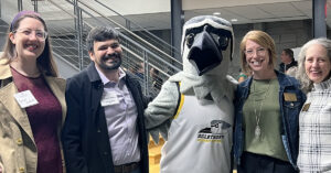 Alumni and faculty pose with Petey mascot