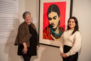 Elizabeth Peterson Jennings and Sophia Sobrino standing in front of an art painting.