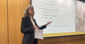 Dr. McClymond speaks in front of a large screen in Lupton Auditorium.