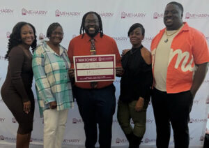 Deon Heavens ’19 holding a sign of his new role as a physician surrounded by his family. 